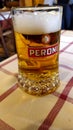Mug of Peroni beer on a table in a typical Roman tavern, with blurred background