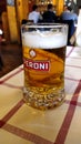 Mug of Peroni beer on a table in a typical Roman tavern, with blurred background