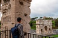 Rome - Tourist man looking from Colosseum with view on Triumphal Arch of Constantine inr Rome, Europe. Royalty Free Stock Photo