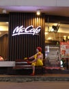 A Ronald McDonald statue, mascot sitting in front of McCafe coffee shop on night view at Porto Chino Community Market Royalty Free Stock Photo