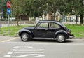 Vintage black Volkswagen Beetle, or Type 1 in a city street. Side view.