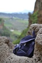 Backpack on rock in Ronda, Andalusian town in Spain at the Puente Nuevo Bridge over the Tajo Gorge, pueblo blanco Royalty Free Stock Photo