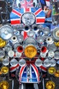 The ront of a moped scooter with 20 head lights and union jack flag