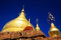 Roof of ancient brick stone temple with golden dome contrasting with deep blue sky - Bagan, Myanmar