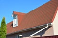 Roof Asphalt Shingles with Moss. Rain Gutter Pipeline with Downspout Pipe and Attic Mansard Window. Royalty Free Stock Photo