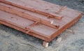 Roof battens beams and osb boards intended for construction lie unwrapped on the ground on a pallet. The slats are painted with th Royalty Free Stock Photo