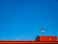 The roof of the building with ventilation and TV antennas, under the bright blue sky Royalty Free Stock Photo