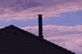 Roof with chimney after sunset. Blue sky with blushes