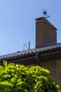 Roof and chimney with vane modern brick rustic cottage. Concept of investment in suburban real estate