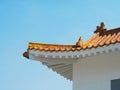 Roof corner of a traditional Chinese building with red tiles and clay figures Royalty Free Stock Photo