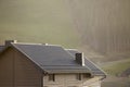 Roof of cottage with siding walls, brown shingle roof and high chimneys in ecological area on foggy landscape copy space Royalty Free Stock Photo