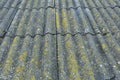 Roof of a country house, covered with gray slate, close-up. Old roof covered with slate. Green moss grows between slate waves. Royalty Free Stock Photo