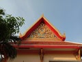 Roof and front of Buddhist temple isolated on blue sky background closeup. Royalty Free Stock Photo