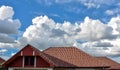 Roof gable and cloudy blue sky background.