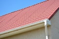 Roof gutter with house red metal tiled roof