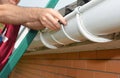 Roof gutter installation. A man on a ladder is installing a roof gutterÃ¢â¬â¢s slip joint connector to connect the gutters and avoid Royalty Free Stock Photo