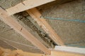 Roof heat isolation with mineral wool in wooden house, building under construction