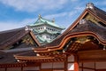 The roof of Hommaru Palace with the main keep of Nagoya castle on the background. Nagoya. Japan