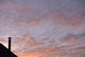 Roof of a house with a chimney on the background of the evening sky with clouds Royalty Free Stock Photo