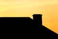 Roof of a house with a chimney at sunset Royalty Free Stock Photo