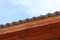 Roof of house made of gray corrugated slate on wooden beams against blue sky background Royalty Free Stock Photo