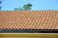 Roof house with tiled roof on blue sky. detail of the tiles and corner mounting on a roof, horizontal. roof protection from snow