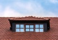 The roof of the house is tiled. Window on the roof of the house. Attic. Blue cloudy sky Royalty Free Stock Photo