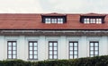 The roof of the house is tiled. Window on the roof of the house. Attic. Blue cloudy sky