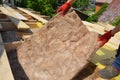 Roof Insulation Close Up. Roofer Contractor Installing House Roof Thermal Insuation with Mineral Wool