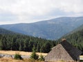 Roof of a mountain hut on a meadow on a ridge with dry grass, with forest and blue sky in the background on an autumn sunny day Royalty Free Stock Photo