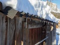 Roof of a Mountain Wood Cottage Covered in Snow with Frozen Drops Royalty Free Stock Photo