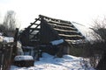 The roof of an old abandoned house in the village in winter. Snowy and Sunny day. Empty house, without people, dilapidated, broken Royalty Free Stock Photo