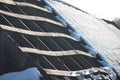 The roof of an old abandoned house in the village in winter. Snowy and Sunny day. Empty house, without people, dilapidated, broken Royalty Free Stock Photo