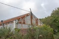 Roof of an old abandoned rusty tin barn building ruin in a green field Royalty Free Stock Photo