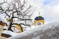 Roof of old building covered with thick snow drift layer after heavy snowfall blizzard and austrian Kufstein town hall .tower with