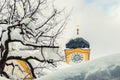 Roof of old building covered with thick snow drift layer after heavy snowfall blizzard and austrian Kufstein town hall .tower with