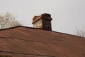 One old large brick chimney on roof of a private house on background blue sky Royalty Free Stock Photo