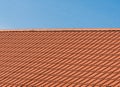 Roof with orange tiles on a background of blue sky. Shingles texture. New roof Royalty Free Stock Photo