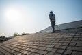 A Roof Repairman, Repair and Replace the House Roof with Handyman with Tools and Pprotective equipment. Stand on the Roof with the Royalty Free Stock Photo