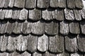 Roof shingles as a traditional rural roof covering. Tiled acute angled cross slab roofing piece material close-up