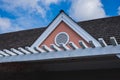 Roof shingles on top of the house against blue sky with cloud, dark asphalt tiles on the roof background.