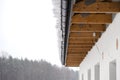 The roof of a single-family house is covered with snow, visible roof trusses and a hanging cap of snow on the gutter. Royalty Free Stock Photo