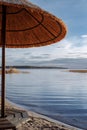 The roof of a straw umbrella against the background of blue water Royalty Free Stock Photo