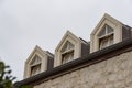 Roof with three beautiful white dormer windows. Ancient round dormer windows in rooftop. Symmetrical view on roof with three