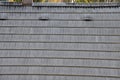 Roof tiles made of plastic imitation wooden shingles. view of rows of gray narrow recycled boards. vents in several elegant bumps.