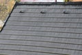 Roof tiles made of plastic imitation wooden shingles. view of rows of gray narrow recycled boards. vents in several elegant bumps.