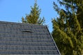 Roof tiles made of plastic imitation wooden shingles. view of rows of gray narrow recycled boards. vents in several elegant bumps.