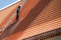 Roof top worker with professional equipment Cleaning the roof of the house with a pressure tool. Royalty Free Stock Photo