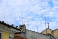 Roof tops of old buildings with antennas on cloudy blue sky background Royalty Free Stock Photo