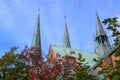 Roof, towers and ridge turret of the luebeck cathedral, detail of the historic brick church against a blue sky with feather clouds